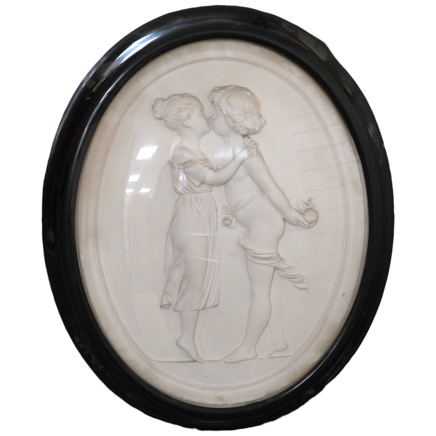 An early 20th century framed oval plaster plaque, classical scene, monogrammed TS, convex glass, 80cm long